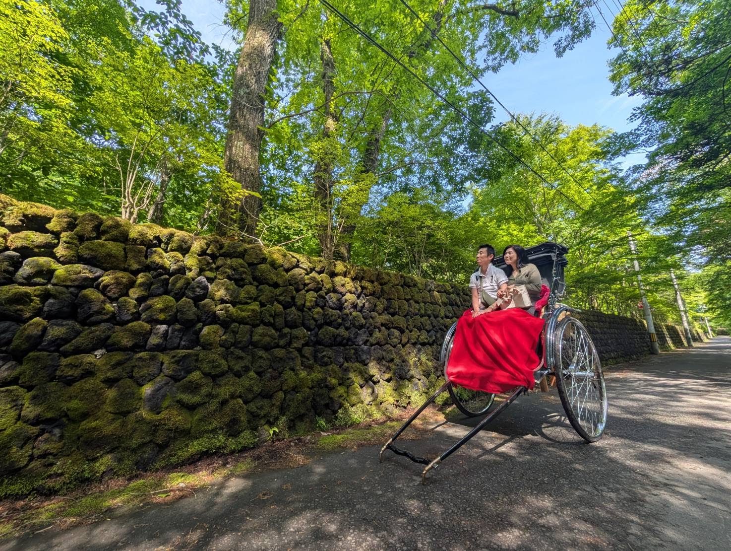 苔むした石垣の小径を行く人力車