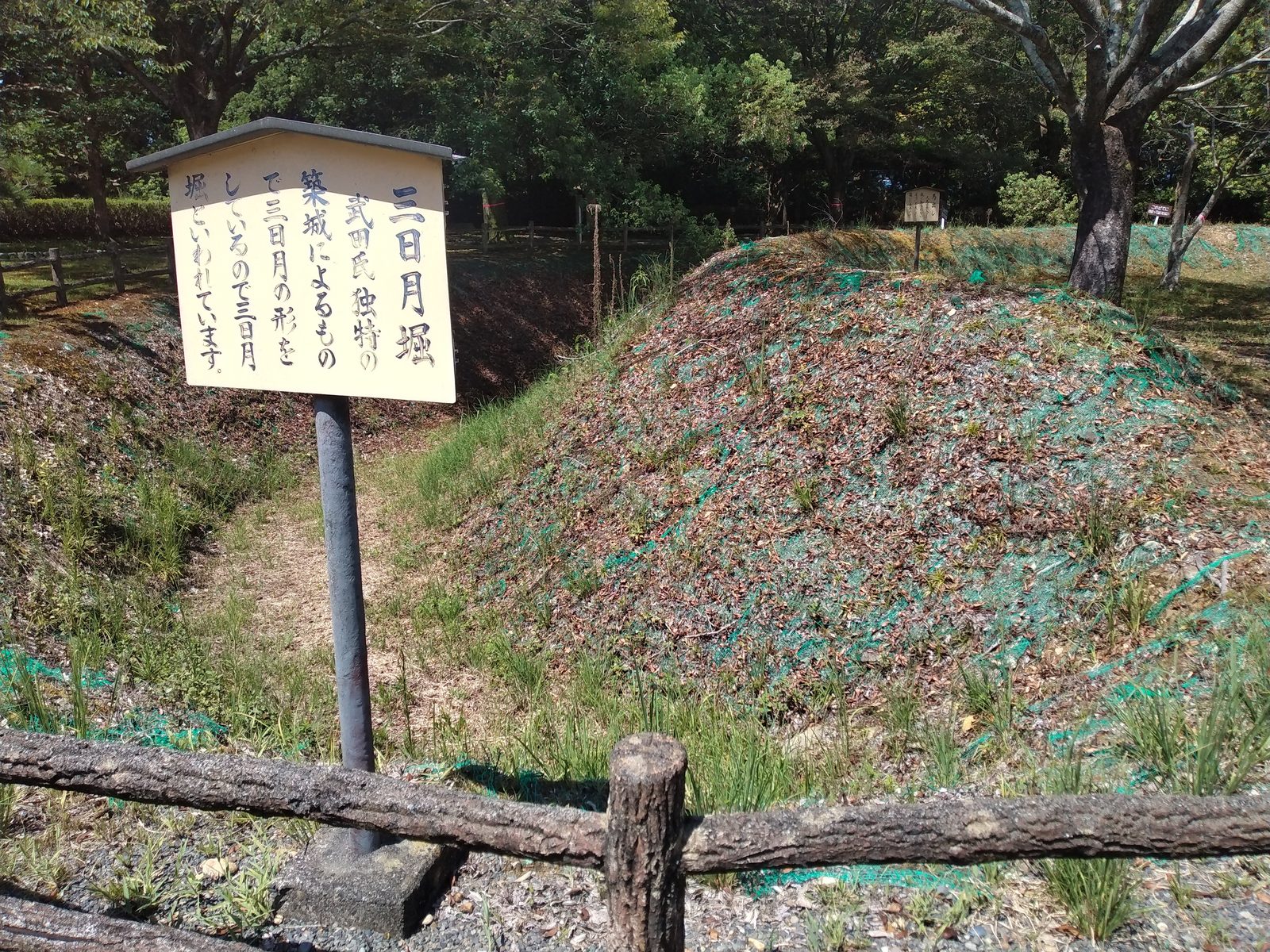 小山城の三日月堀の説明板と土塁