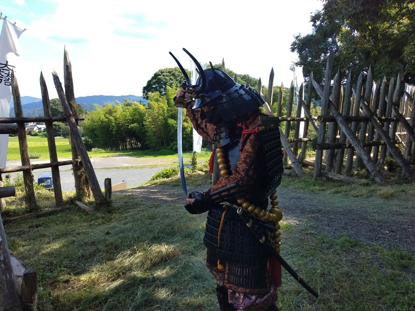 刀を手に関ケ原の古戦場に立つ