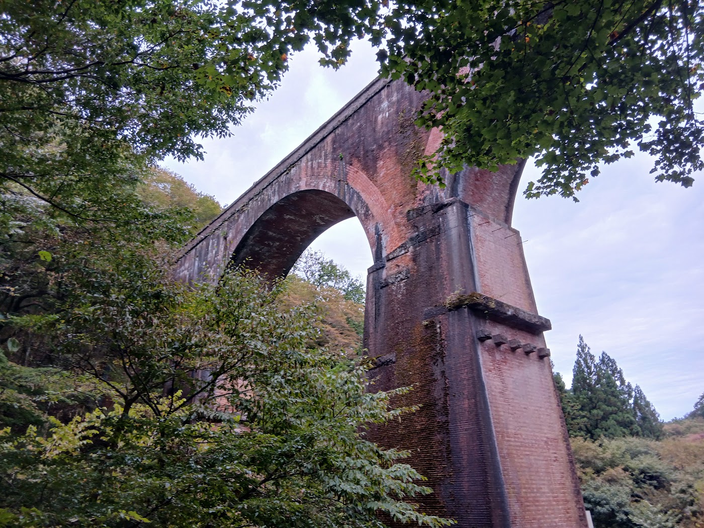 木々の間から見ためがね橋のアーチ